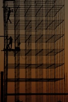 a man working on a scaffold at sunset