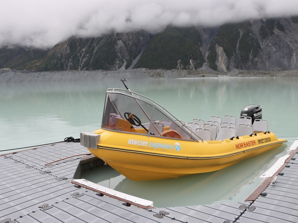 a yellow boat sitting on top of a body of water