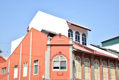 a red building with a white roof and windows
