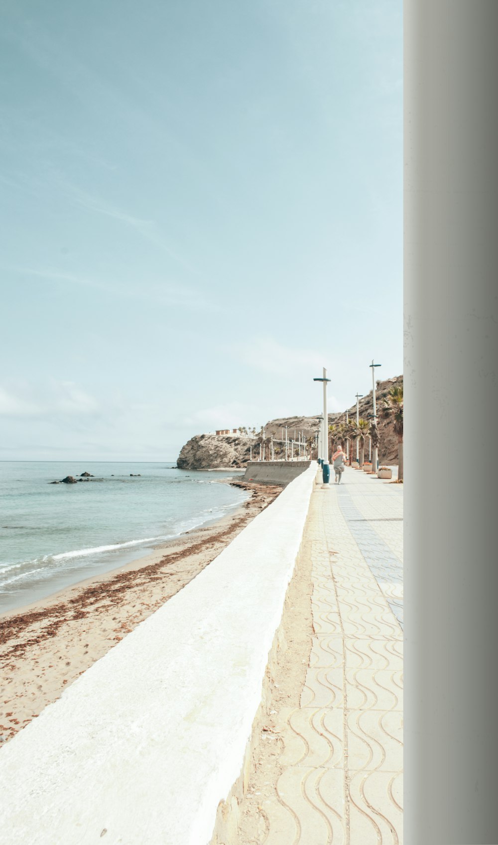 a beach with people walking on the sand and the ocean in the background