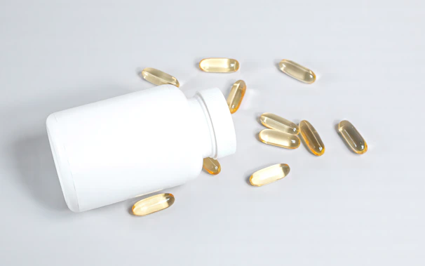 Close-up of white detox capsules spilling gently onto a smooth, clean surface.
