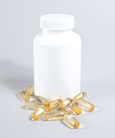 Close-up of ProDentim capsules spilling gently from the bottle onto a clean white surface.