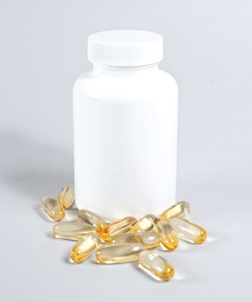 Close-up of a Digeros Forte vitamin D supplement bottle with scattered vitamin capsules around it on a clean surface