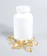 Close-up of a translucent white supplement bottle with a matte gold cap on a soft off-white background with natural light.