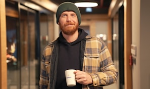 a man with a beard holding a cup of coffee