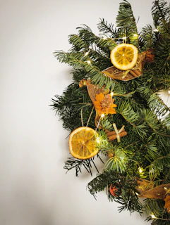 A festive wreath adorned with dried orange slices, cinnamon sticks, and deep red berries, perfect for holiday decor.