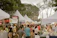A lively outdoor community event with people enjoying music and food stalls.