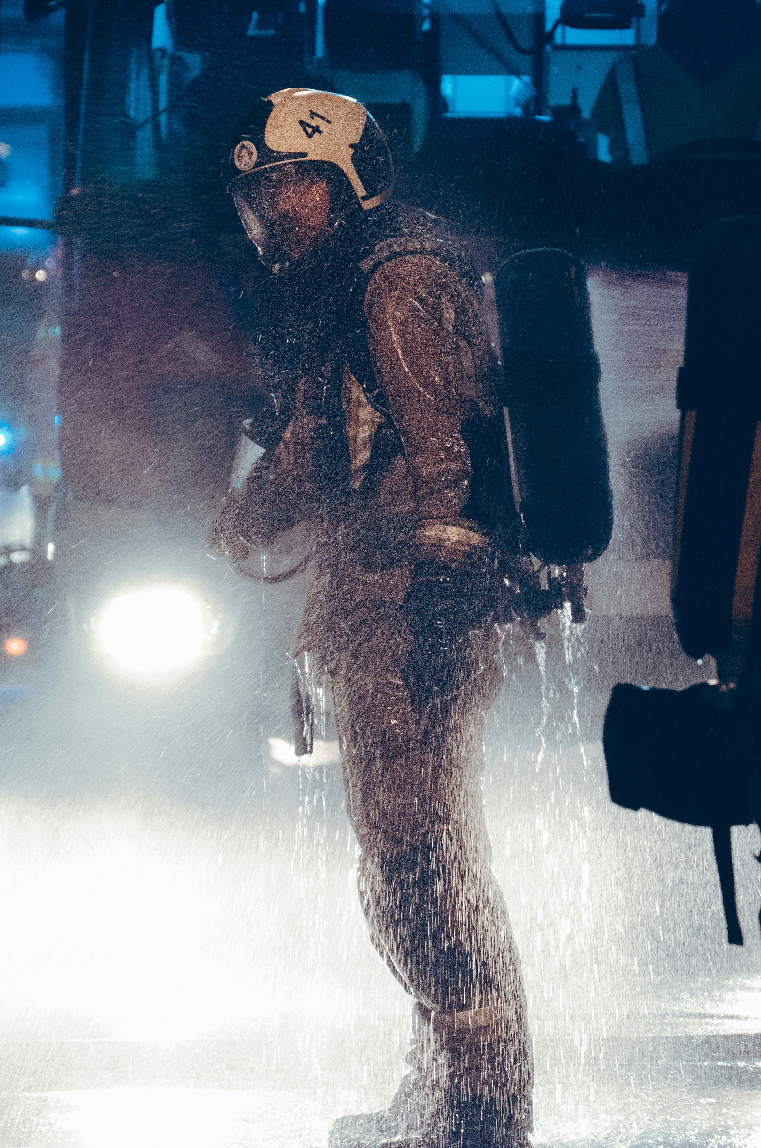 a man in a wet suit and helmet standing in the rain
