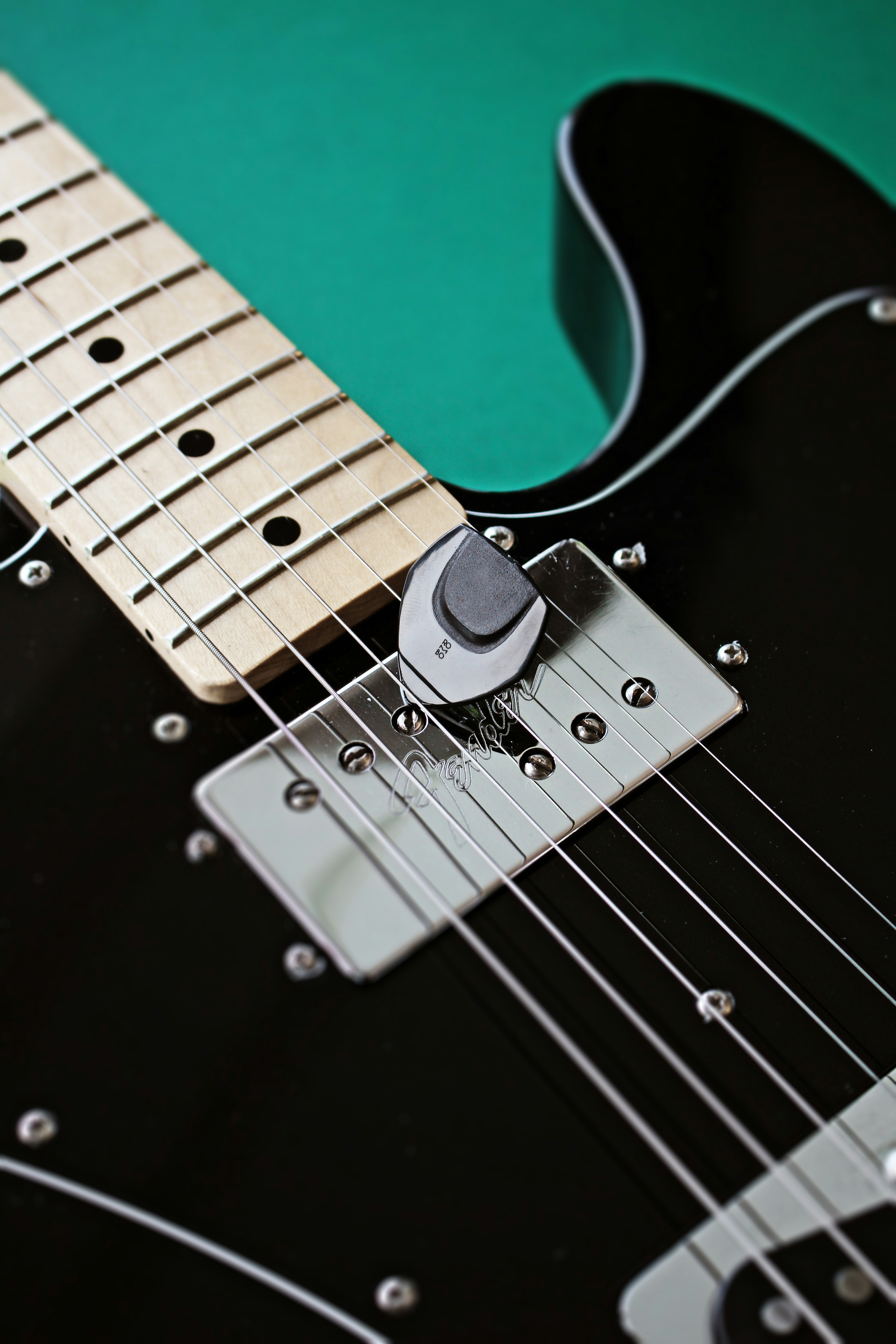 a black electric guitar with a green background