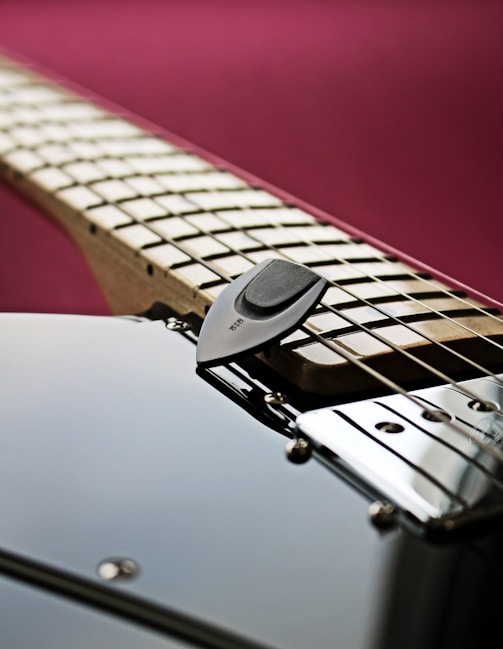 a close up of an electric guitar with a pick