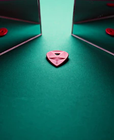 a red heart sitting on top of a green table