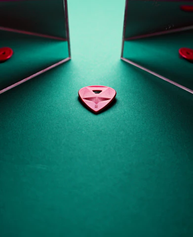 a red heart sitting on top of a green table