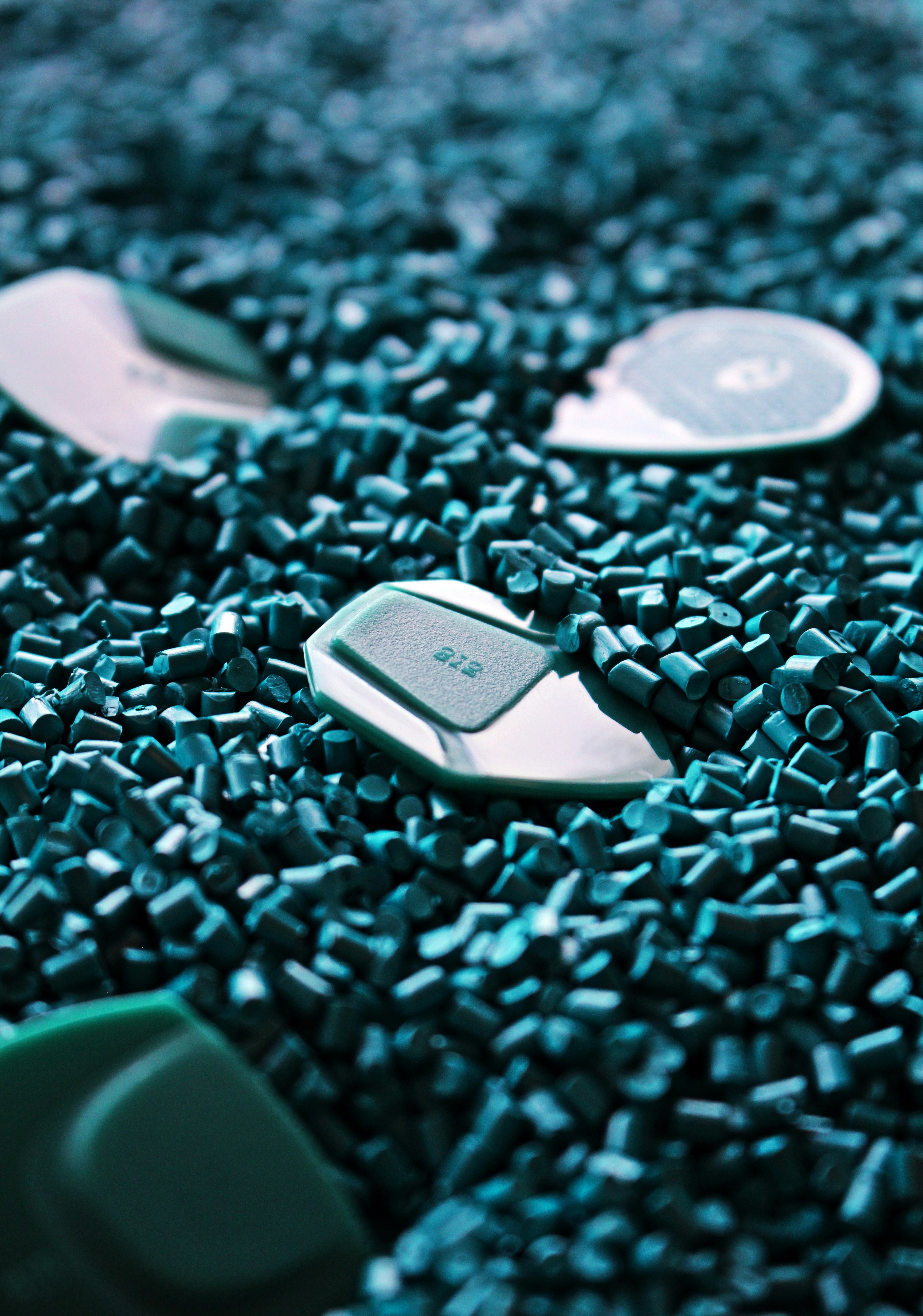 Small dark teal plastic pellets with light plastic tokens.