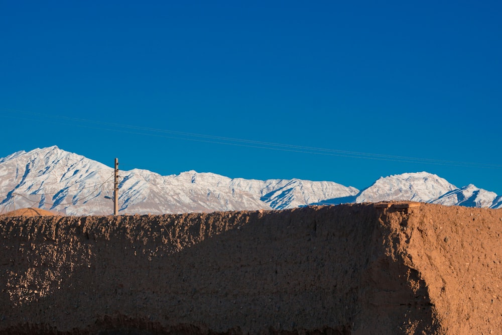 a view of a mountain range with a telephone pole in the foreground