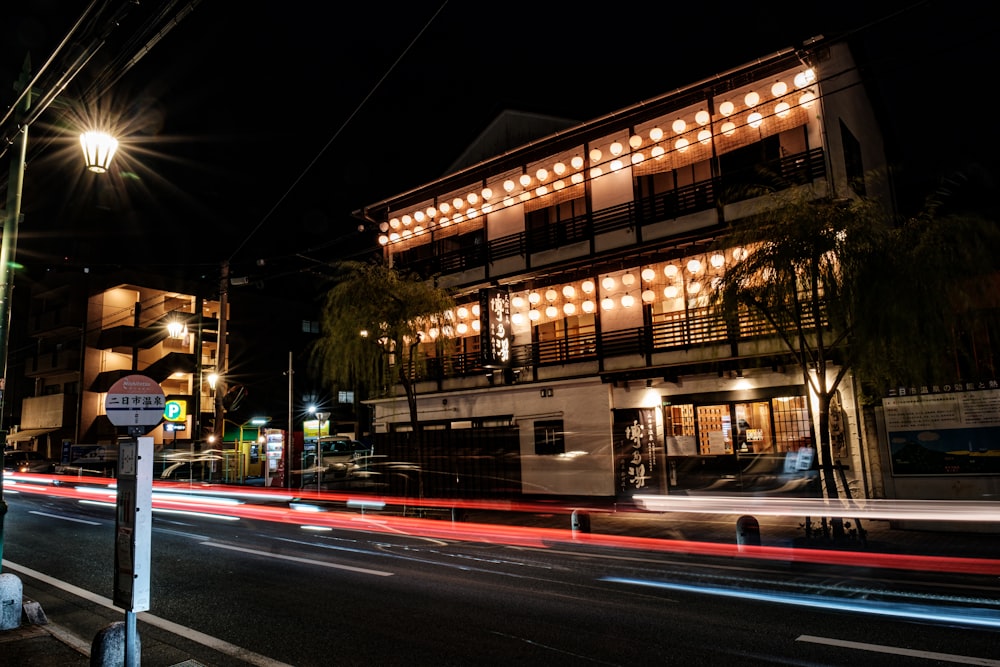 a city street at night with a building lit up