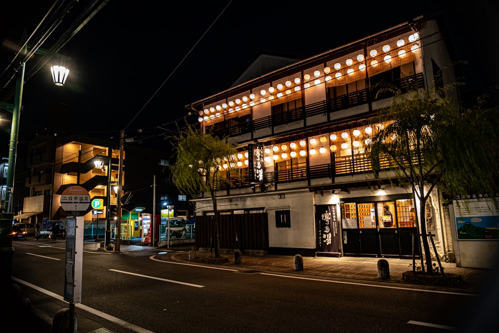 a street at night with a building lit up