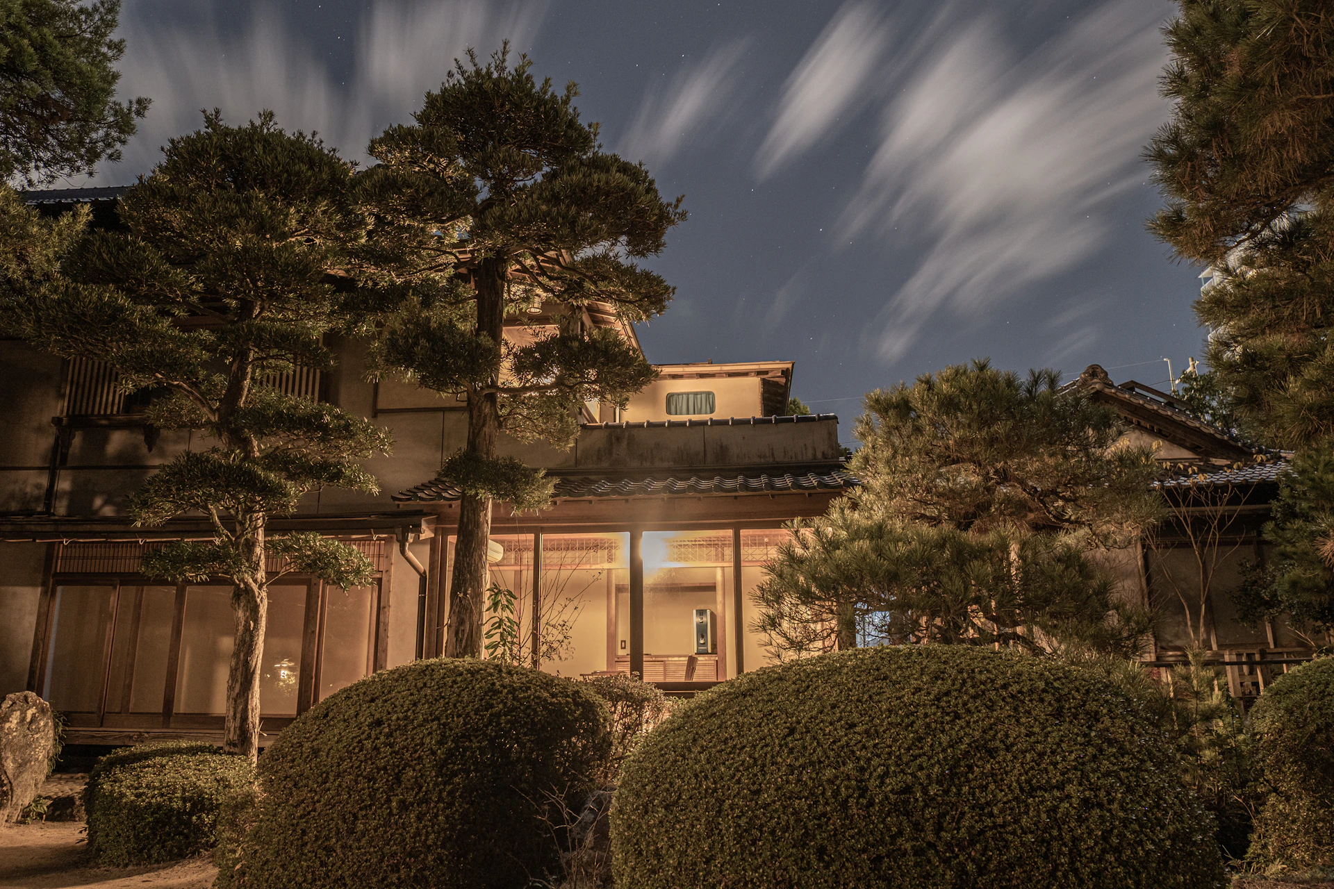 満天の星空の下、松の木立に囲まれて灯りをともす山あいの木造の宿