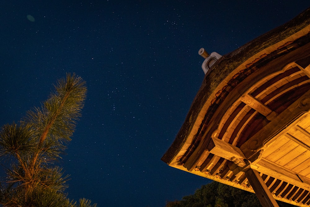 a night time view of a wooden structure with stars in the sky