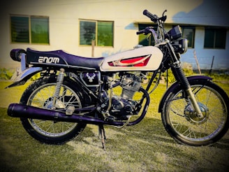 A vintage motorcycle with chrome details parked in front of an American flag backdrop.