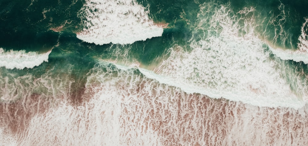 an aerial view of the ocean with waves