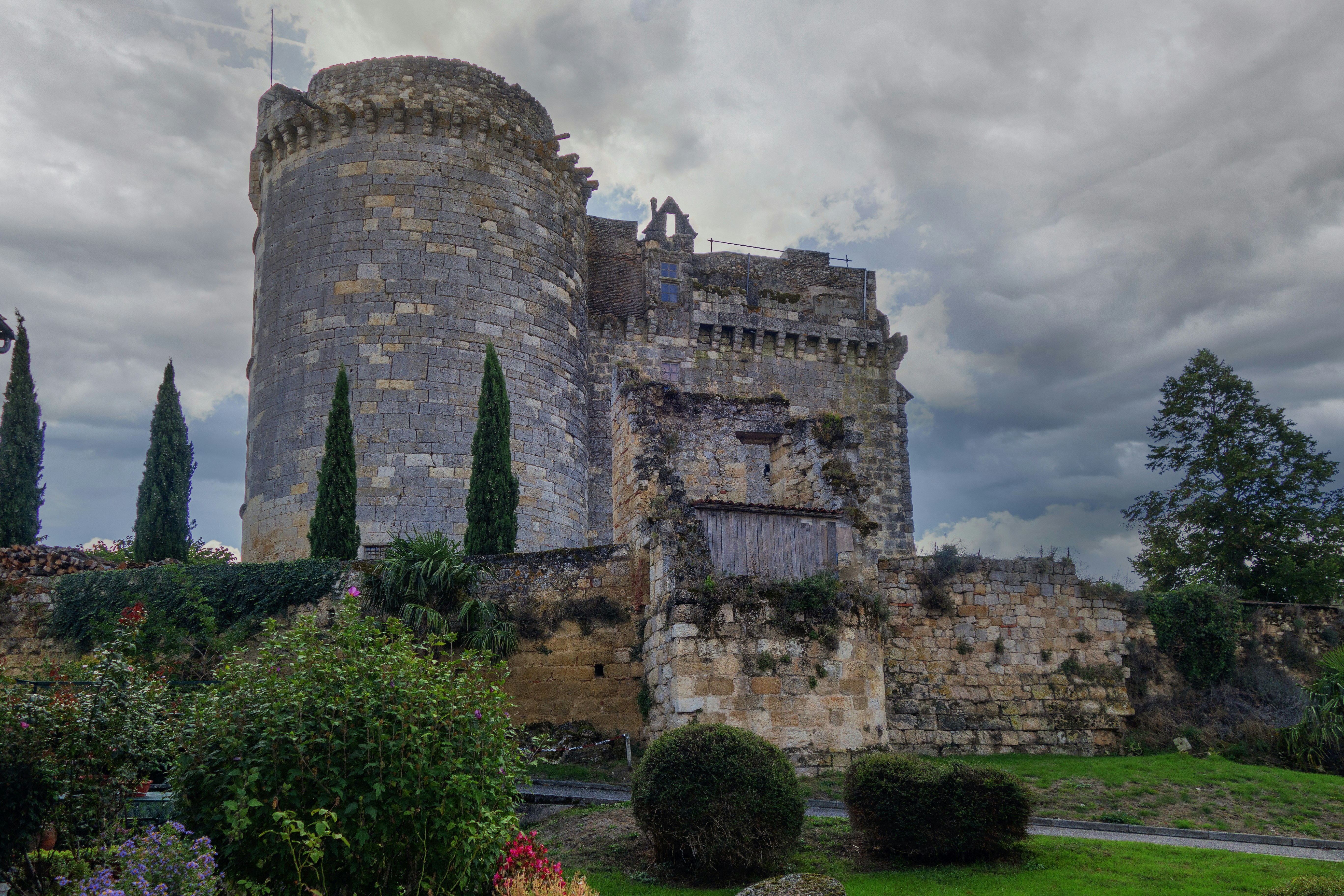 a castle with a tower and a lot of trees in front of it