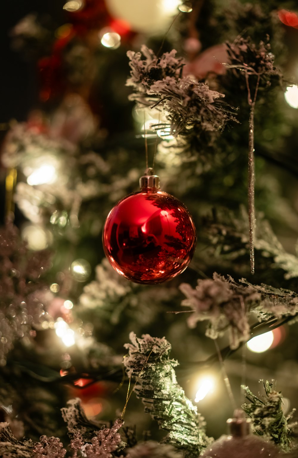 a red ornament hanging from a christmas tree