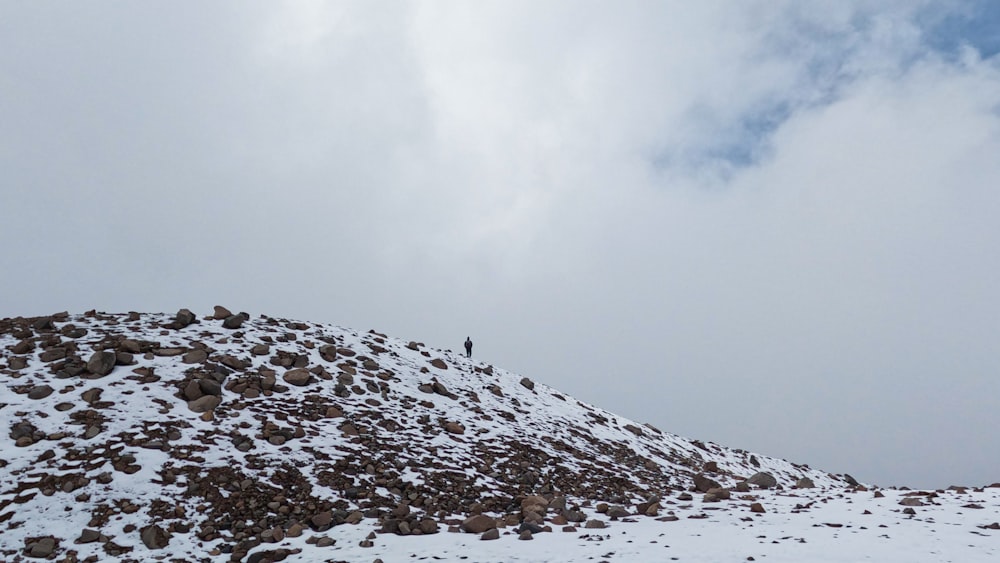 a man standing on top of a snow covered mountain