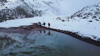 a group of people walking across a snow covered field