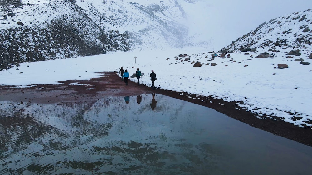 a group of people walking across a snow covered field