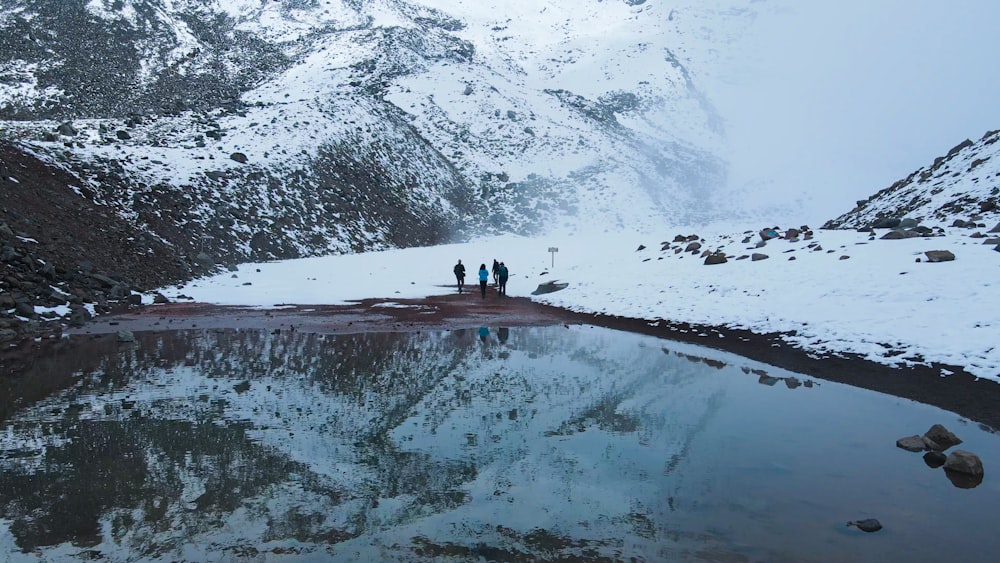 Un gruppo di persone in piedi sulla cima di una montagna coperta di neve