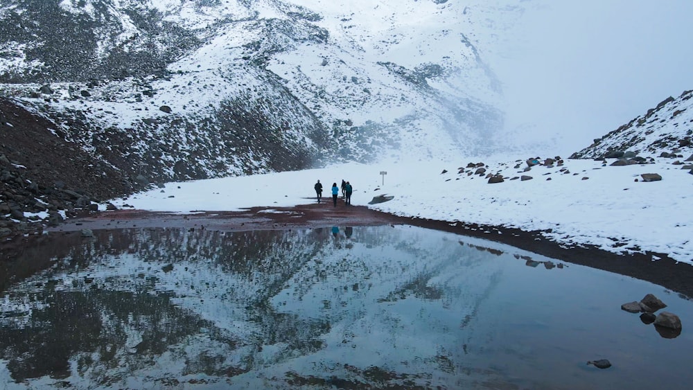 a group of people standing on top of a snow covered mountain