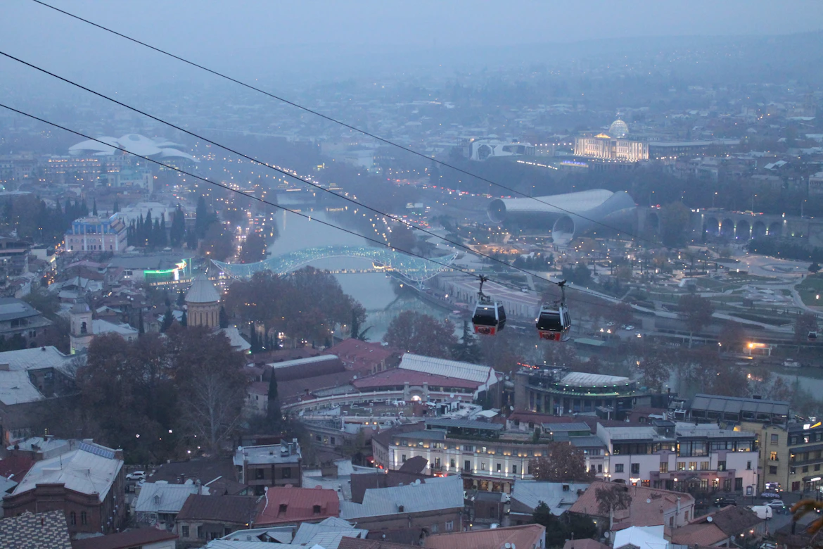 Cable car flying over Tbilisi cityscape