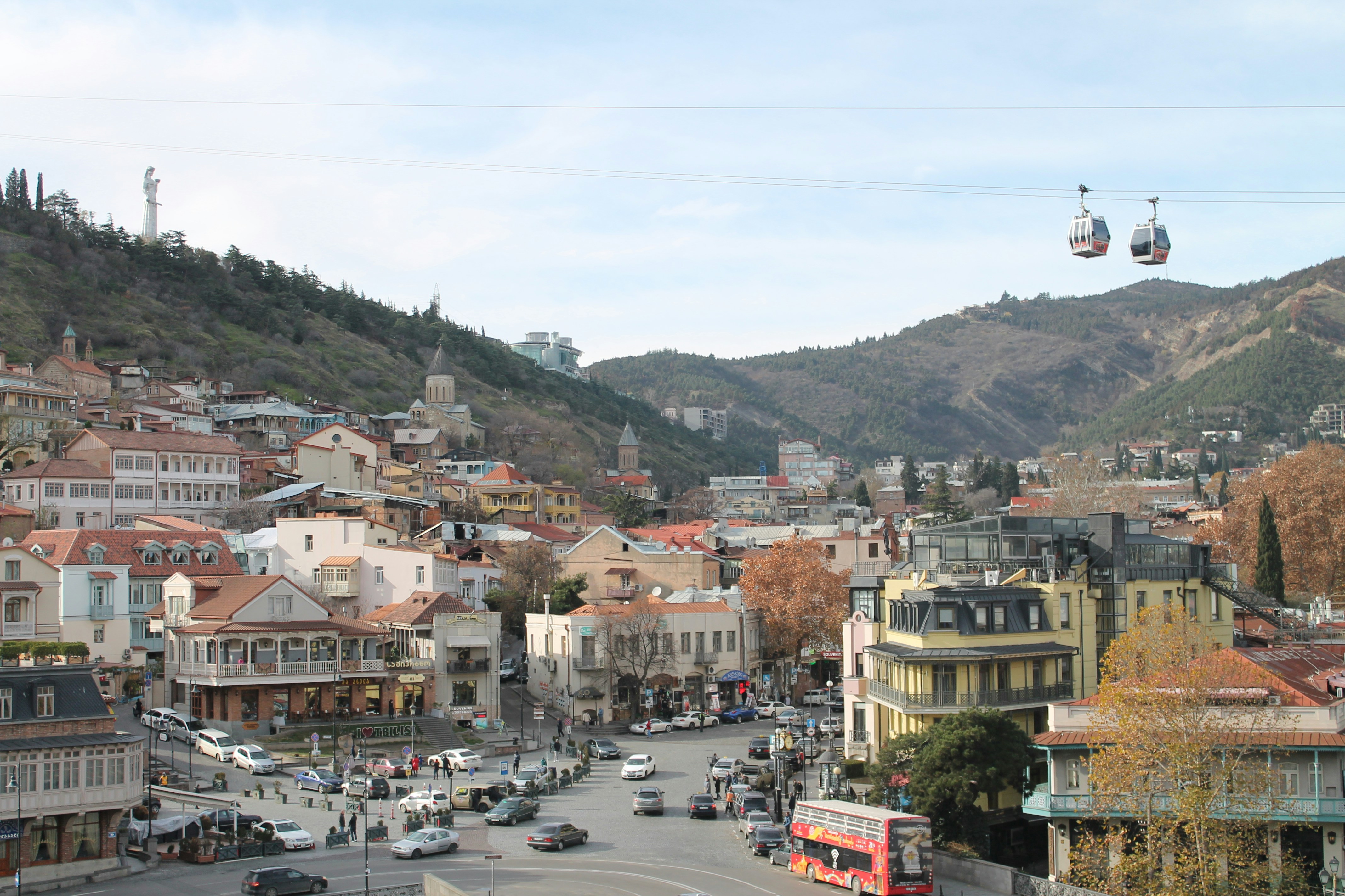 a city street with a cable car going over it