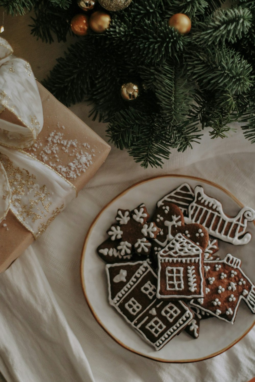 a plate of cookies next to a christmas tree