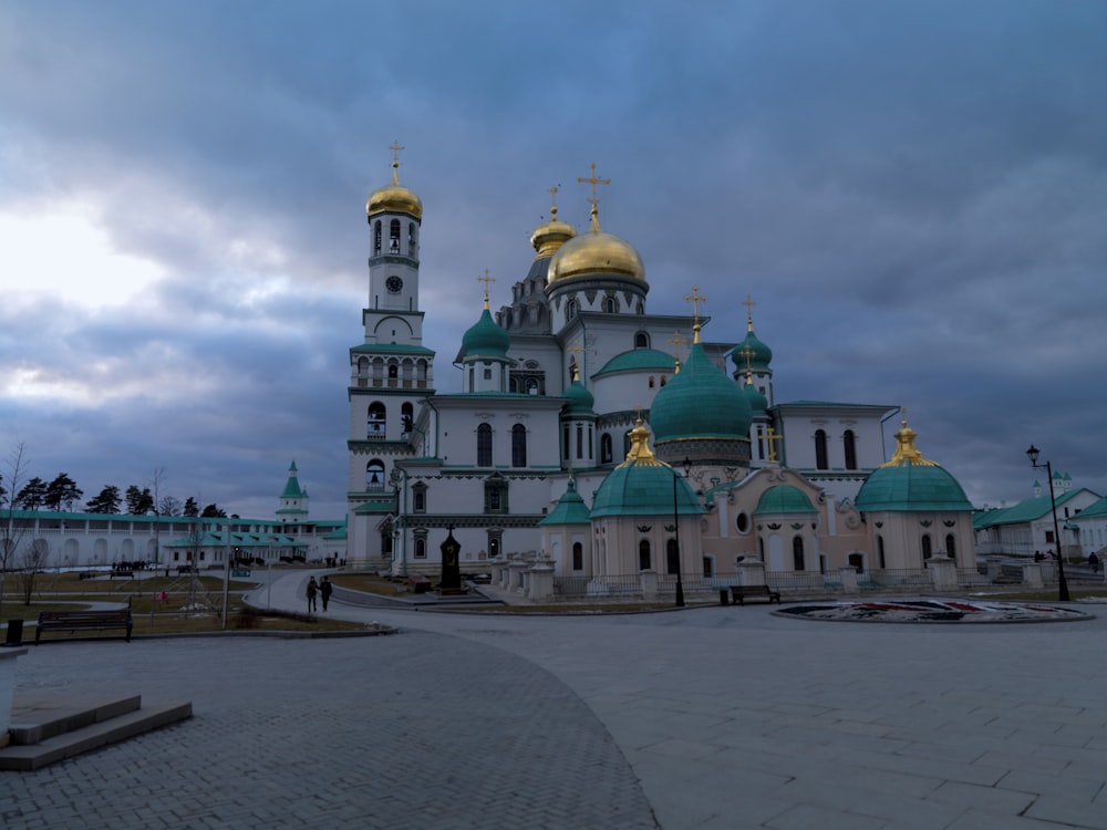 a large white and blue building with gold domes