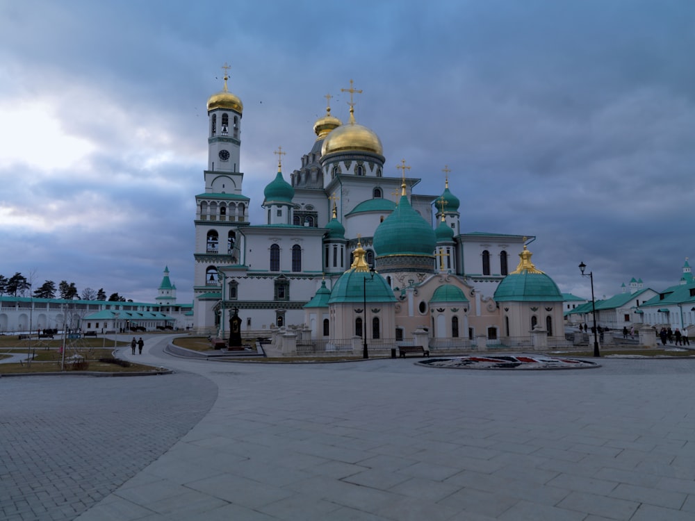 a large white and blue building with gold domes