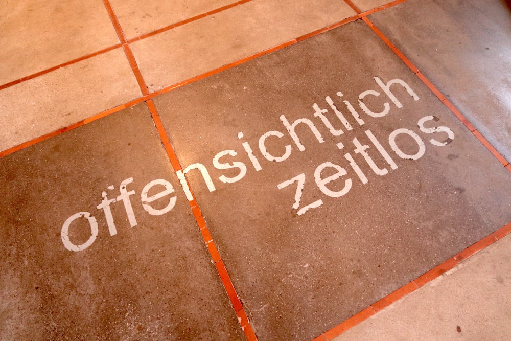 a sign on a tiled floor that says offensschtitch zeillos