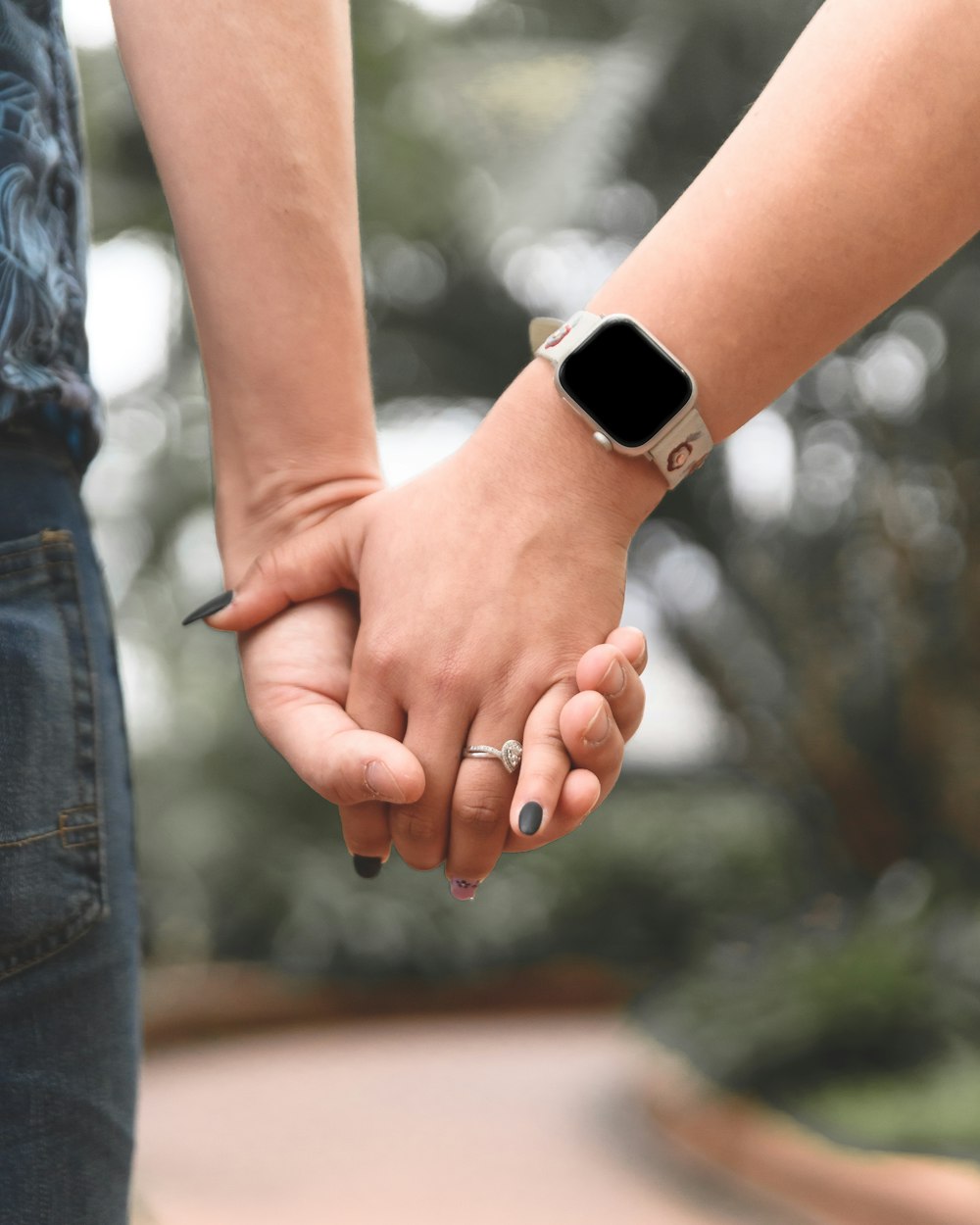 a close up of two people holding hands