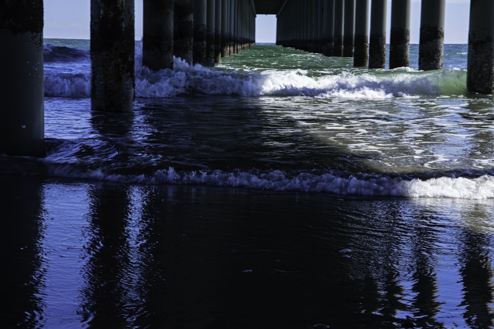 a view of the ocean from under a pier