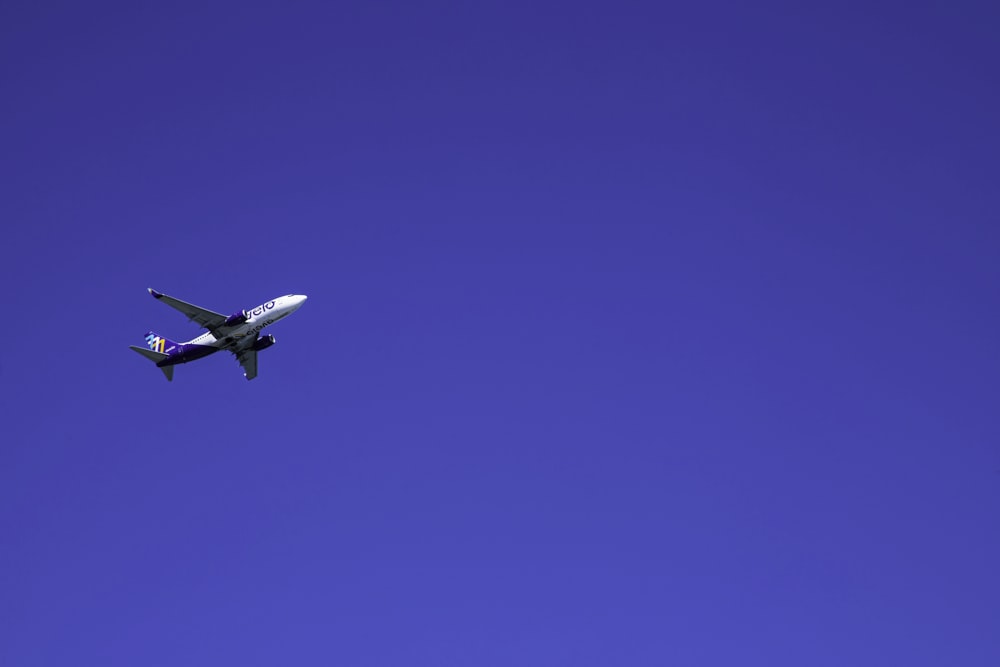 an airplane is flying in the blue sky