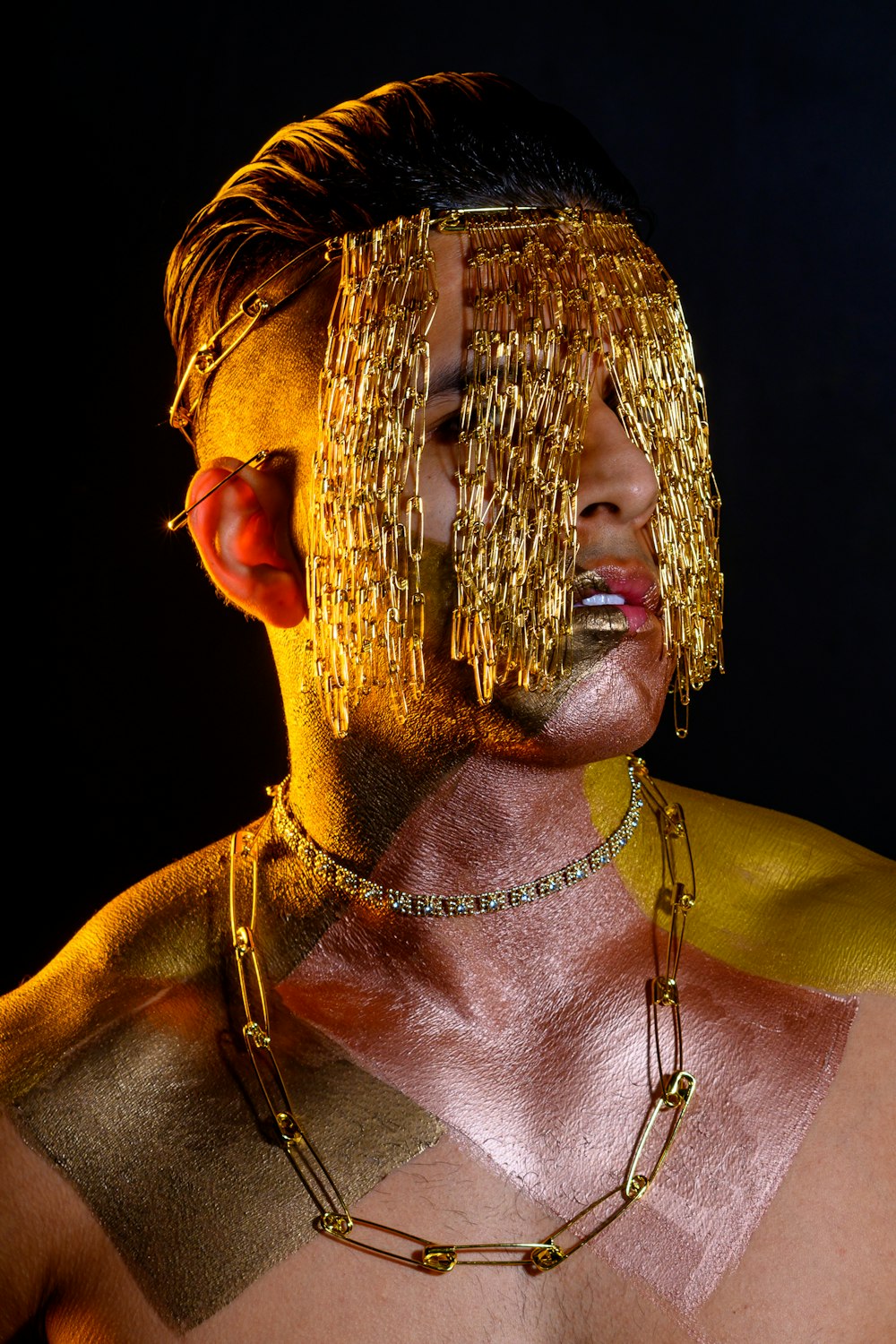 a man with gold paint and chains on his face