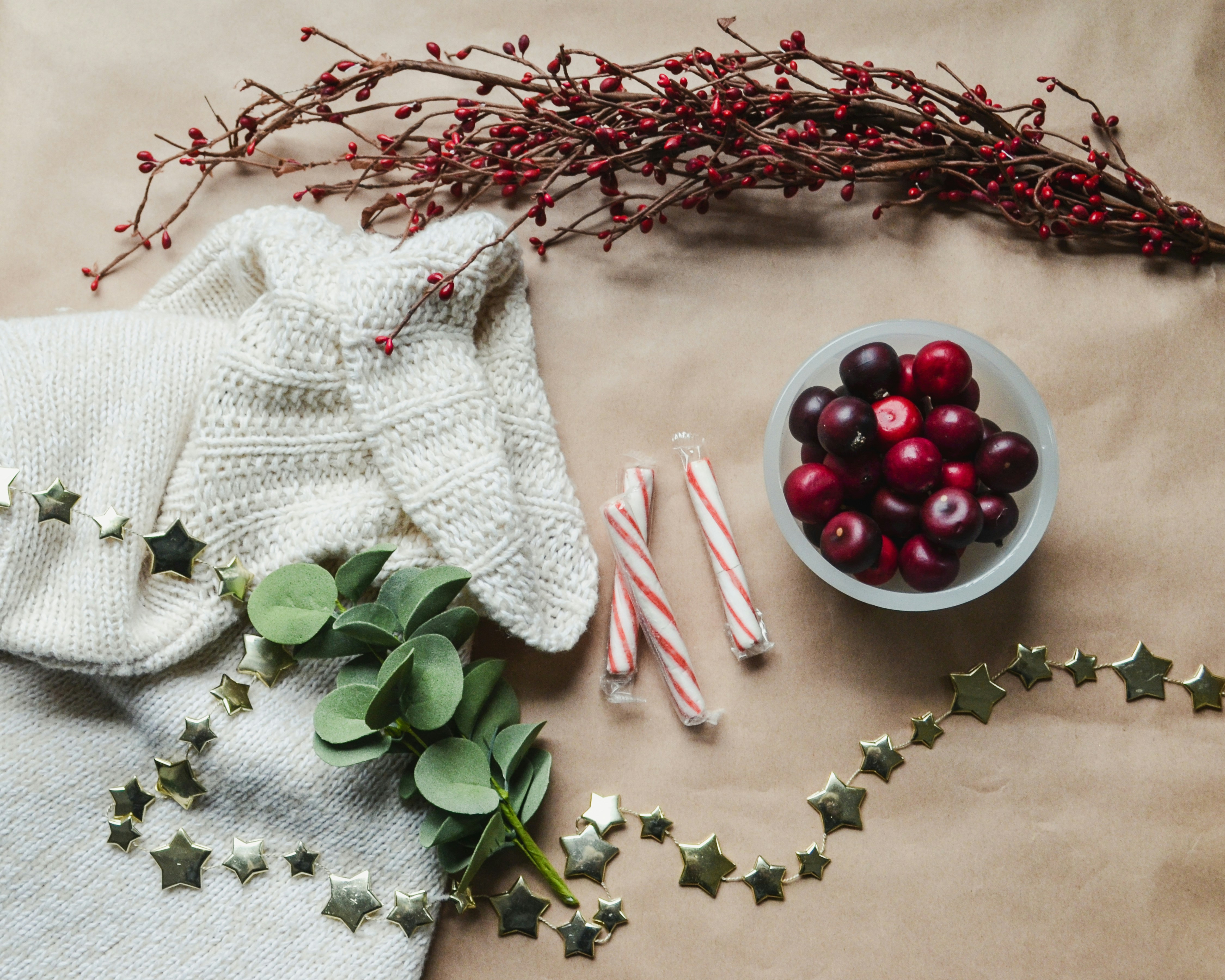 a bowl of cherries next to some candy canes