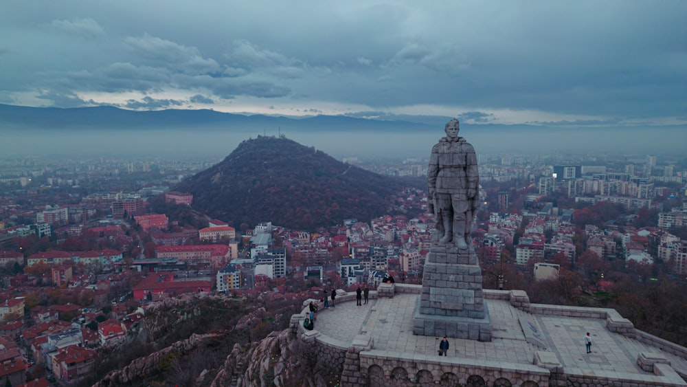 a statue on top of a hill overlooking a city