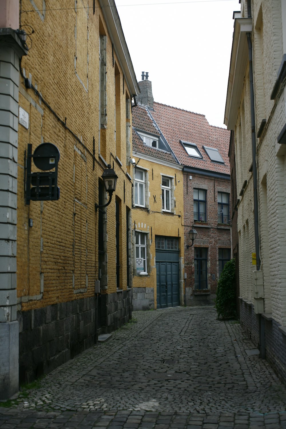 a cobblestone street with a yellow brick building