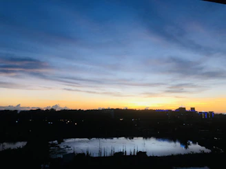 A serene sunset over a city skyline with digital currency symbols subtly integrated into the clouds.