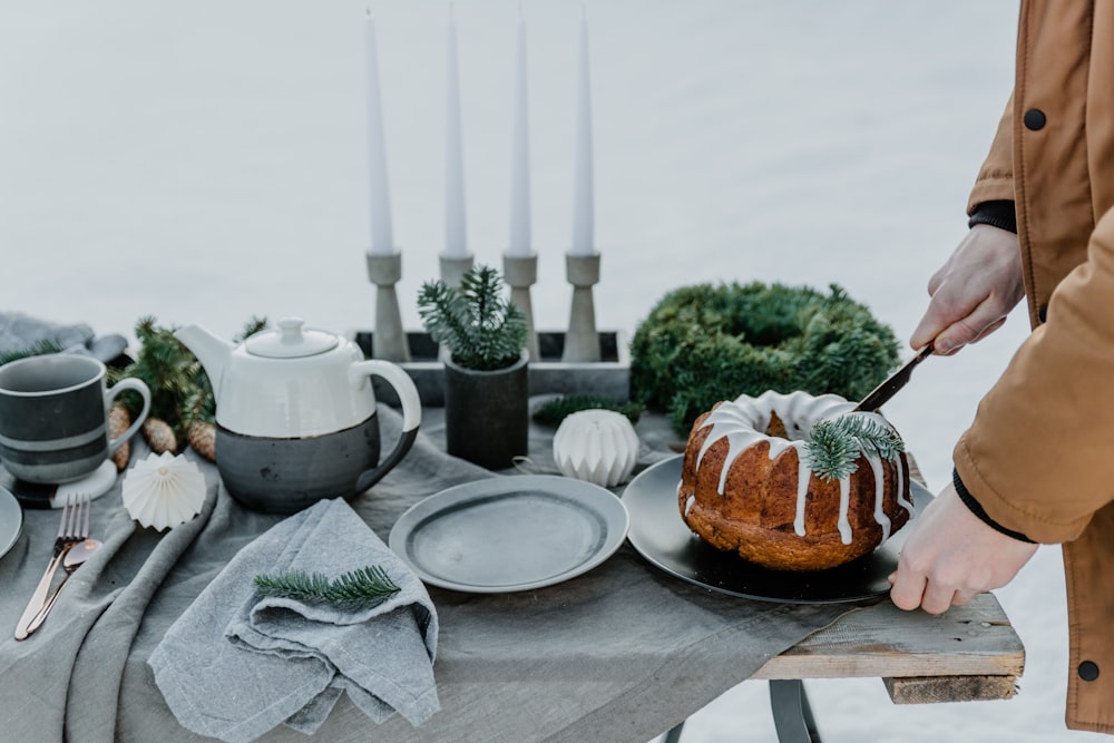 a person cutting a bundt cake on a table