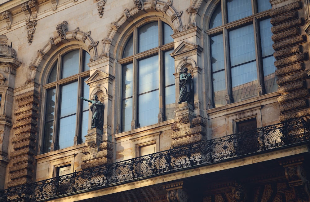 a building with statues of men on the windows