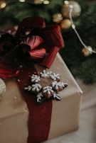 A beautifully wrapped gift box topped with a unique Christmas card decoration from bouhaka llc.