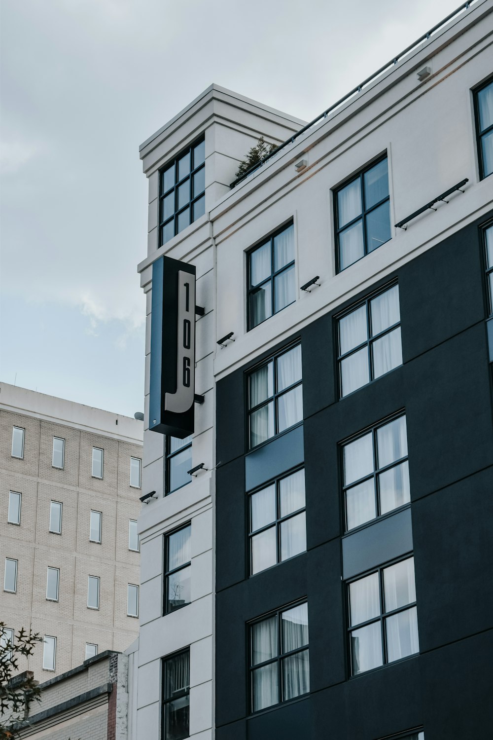 a tall black and white building next to a tall white building