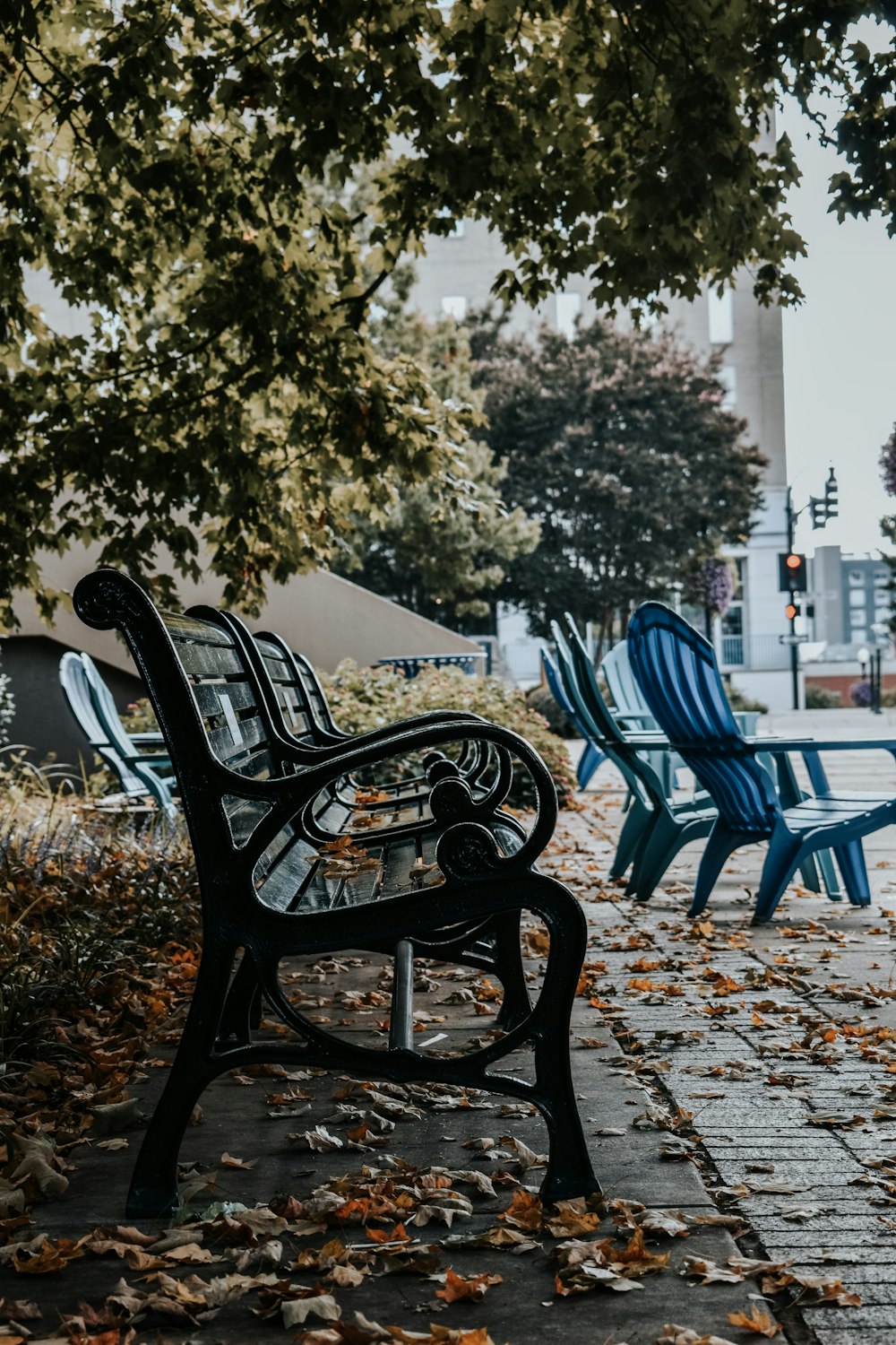 a row of blue chairs sitting on top of a sidewalk
